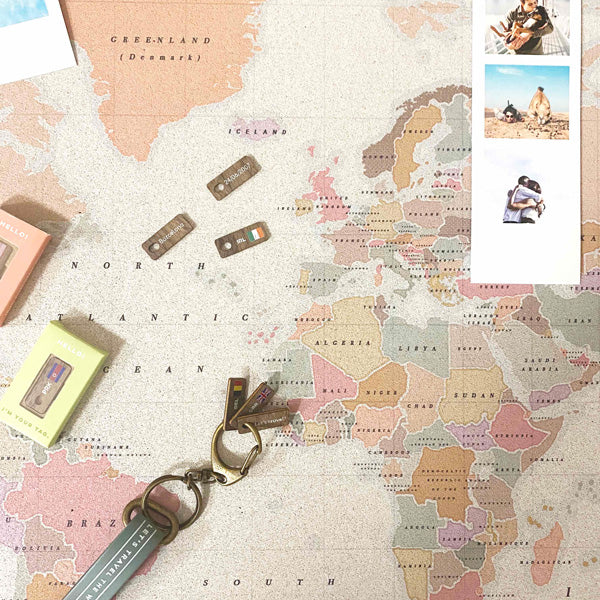 Varias tags con su caja diseñada, encima de un mapa watercolor